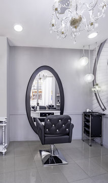 Modern bright beauty salon or baber shop. Hair salon interior business with black and white luxury decor. Detail of the chair and mirror