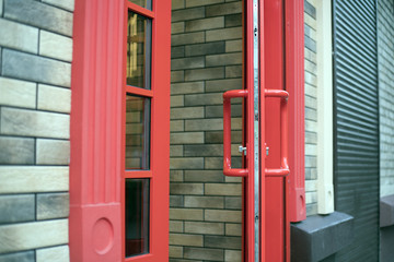 Obraz premium Big open red door. Entrance to the building or room. old lanterns, next to the door.