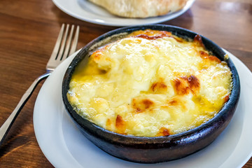 Fried suluguni cheese. Georgian national dish in a clay plate.