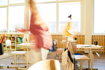 Foolishness at school break: unrecognizable students running over class and having fun at break in...