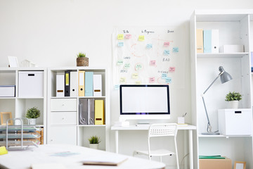 Contemporary office with shelves, desks, computer monitor, chair, lamp and other supplies