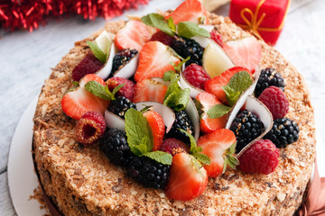 Napoleon cake with fresh berries mint and Christmas background
