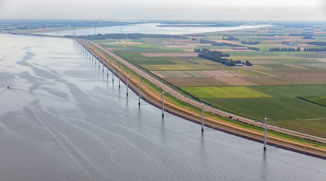 Aerial view row offshore wind turbines along coast and dike of Flevoland, The Netherlands
