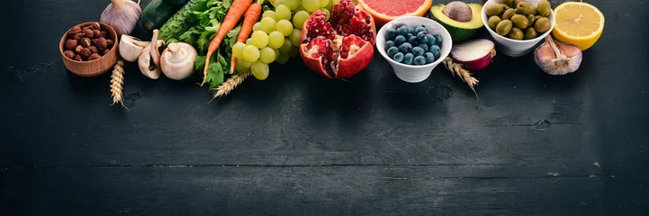 Keuken spatwand met foto Healthy food clean eating selection: Vegetables, fruits, nuts, berries and mushrooms, parsley, spices. On a black background. Free space for text. © Yaruniv-Studio