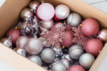 Fototapeta na wymiar assortment of christmas decorative balls in a box. mix of silver and rose gold baubles snowflakes and toys. festive embellishments and new year celebration concept.