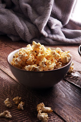 Salt popcorn or sweet popcorn in bowl on the wooden table