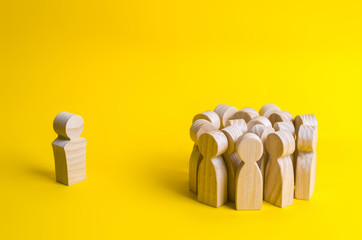 The crowd of wooden figures of people stand distantly and look at the red man. The rejected person...