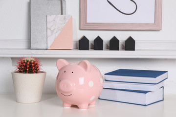 Color piggy bank on table in room. Cute interior element