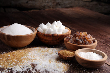 Various types of sugar, brown sugar and white on wooden table