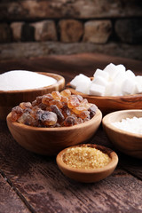 Various types of sugar, brown sugar and white on wooden table