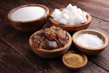 Various types of sugar, brown sugar and white on wooden table