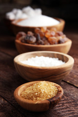 Various types of sugar, brown sugar and white on wooden table