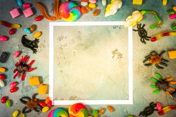 Trick and treat - colorful halloween candies flat lay scene on stone with copy space, retro toned
