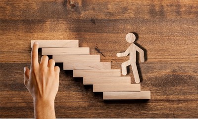 Success concept with wooden businessman climbing wooden
