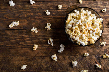 Obraz na płótnie Canvas Air salty popcorn.A bowl of popcorn on a wooden table.Salt popcorn on the wooden background . With space for text.Top view.popcorn texture.Chees .