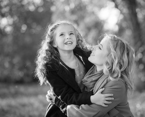Happy joyful woman having fun with her girl in autumn color