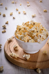 Salt popcorn on the wooden table, selective focus