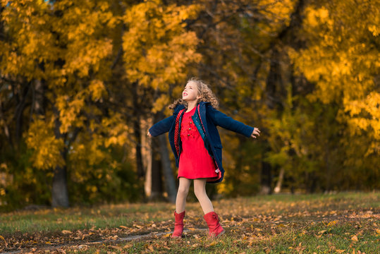 Autumn girl happy with colorful fall leaves falling
