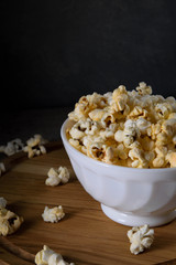 Air salty popcorn.A bowl of popcorn on a wooden table. Rustic style.