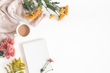 Autumn composition. Cup of coffee, notepad, fresh flowers on white background. Autumn, fall...