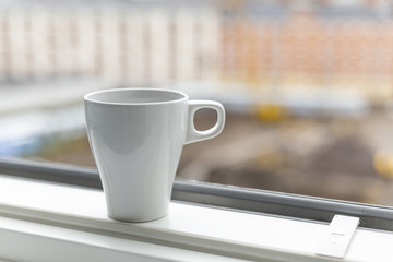 A cup of coffee on the windowsill. Big window. Scandinavian style