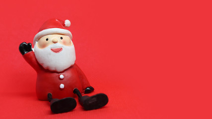 Cute santa doll in red textured background with copyspace to the right
