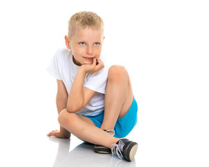 little boy is sitting on the floor