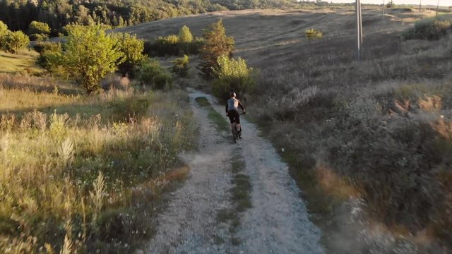 aerial view of cyclist walking down mountain road