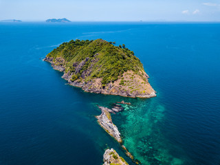 Aerial drone view of a beautiful remote tropical island surrounded by coral reef