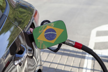 Fueling car with petrol pump at a gas station.