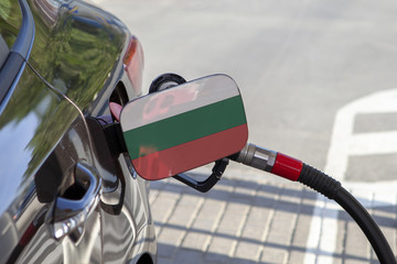 Fueling car with petrol pump at a gas station.