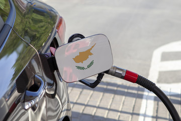 Fueling car with petrol pump at a gas station.