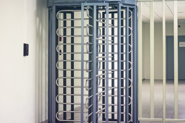 Entrance through big in full human growth steel turnstiles. Concept of security with electronic pass