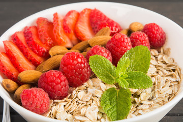 Closeup of view of dry oatmeal with fresh berries and nuts