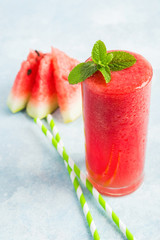 A glass of watermelon beverage with mint