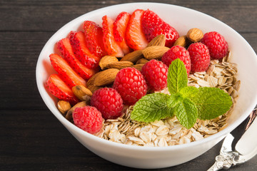 Dry oatmeal with berries and nuts, healthy breakfast concept