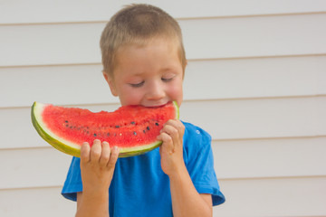 Summer, The child eats a juicy watermelon. Merry boy and watermelon.