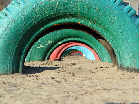 Old car tires on the playground. Old multi-colored car tires.