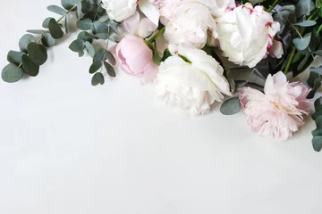 Rollo Pfingstrosen Styled stock photo. Decorative still life floral composition. Wedding or birthday bouquet of pink and white peony flowers and eucalyptus branches. White table background. Flat lay, top view.