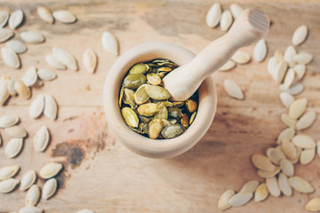 A wooden mortar full of seeds for grinding