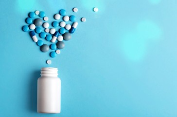 Heart sign make of pills on blue
