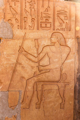 stone wall with Egyptian carving figures and hieroglyphs, Aswan, Egypt, Africa.