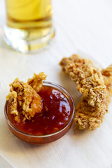 Fried chicken strips with cold beer and sauce, side view. Closeup.