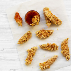 Fried chicken strips with sauce on white wooden surface, top view. Flat lay, from above, overhead. Closeup.
