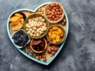 Mix dried fruits and nuts on gray background. Top view of superfoods.