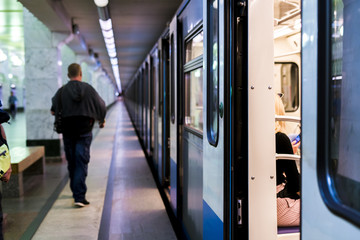 subway train staying on a metro station with doors open with defocused background