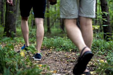 close up people legs walking in the autumn forest on a camping hiking trip