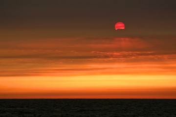 Dramatic Sunset over the Pacific Ocean Caused by Wildfire Smoke