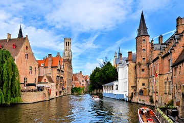 Obraz premium Widok na średniowieczne kanały Brugii ze słynną dzwonnicą