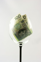 Two banknotes one hundred Polish zlotys inside the wine glass

